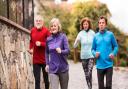 Group of active seniors running together outdoors in the old town of Banska Stiavnica in Slovakia.
