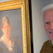 Cllr John Crockford-Hawley pictured beside a portrait of Ivy Millicent James held at Weston Museum.