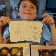 Liam with a note and cakes he baked for NHS workers.