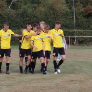 Cheddar players surround Oscar Collins on his match winning goal against Bristol Telephones.
