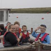 Weston's mayor Cllr Sonia Russe salutes as she sails along the River Axe for the NSPCWT event.