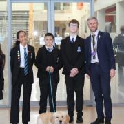 Head of school Adrian Esch celebrates Hans Price Academy’s latest Ofsted success with students and school dog Hanson.